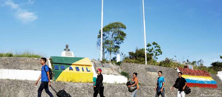 Venezuelanos cruzando a fronteira para chegar ao Brasil. Mais de 17 mil pediram refúgio em 2017.