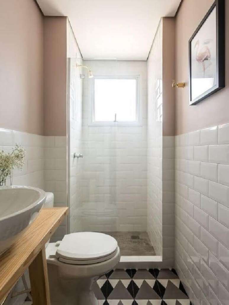 5. Modelo de banheiro pequeno com subway tile e piso com desenhos geométricos.