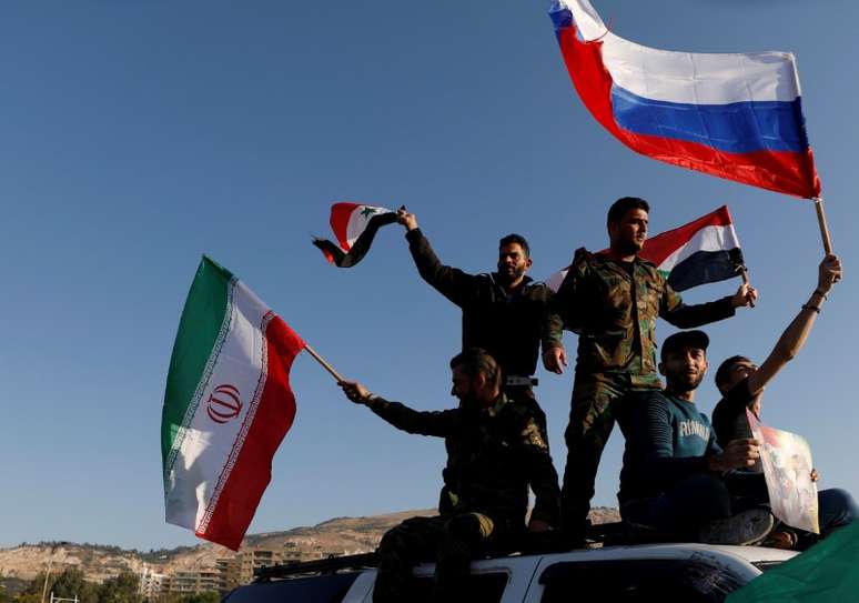 Sírios agitam bandeiras da Rússia e do Irã durante protesto contra ataque aéreo liderado pelos EUA em Damasco
14/04/2018
REUTERS/ Omar Sanadiki