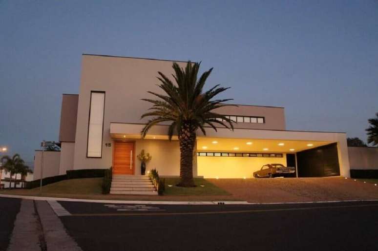 23. Frente de casa moderna com telhado platibanda e cores neutras