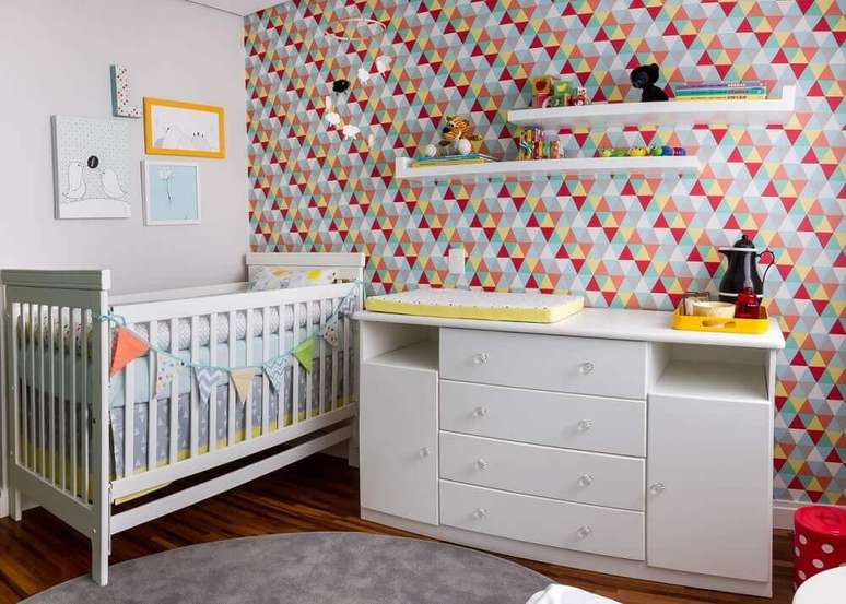 18. Quarto de bebê com papel de parede estampado com triângulos coloridos