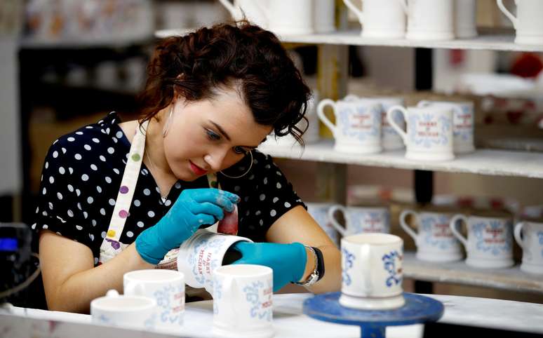 A worker prints a design onto a souvenir mug to commemorate the wedding of Britain's Prince Harry and Meghan Markle at the Emma Bridgewater Factory, in Hanley, Stoke-on-Trent, Britain March 28, 2018. Picture taken March 28, 2018. REUTERS/Carl Recine - RC130C39F310