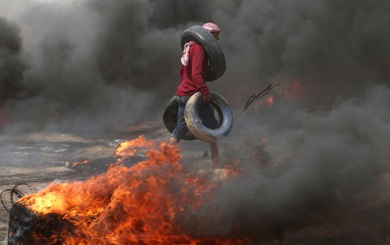 Manifestante carrega pneus durante conflito com tropas israelenses na fronteira entre Israel e Gaza, no sul da Faixa de Gaza
20/04/2018
REUTERS/Ibraheem Abu Mustafa 
