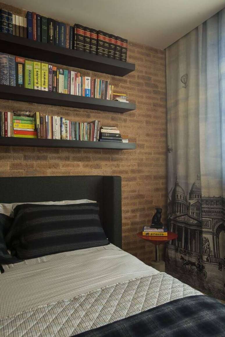 23. Decoração de quarto masculino com parede de tijolinho e prateleira de livros