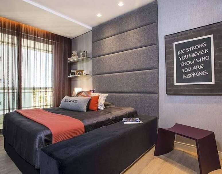 36. Decoração de quarto jovem masculino com cabeceira estofada cinza que se estende até o teto