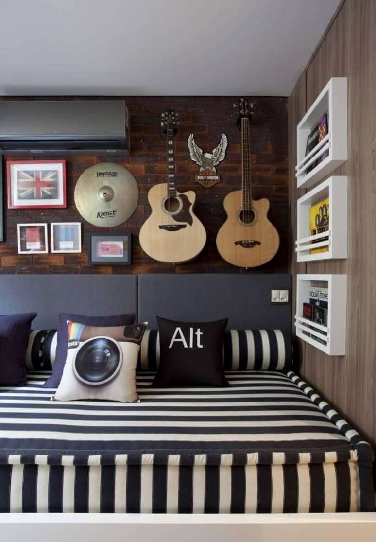 44. Decoração de quarto jovem masculino com violão e quadros na parede de tijolinho