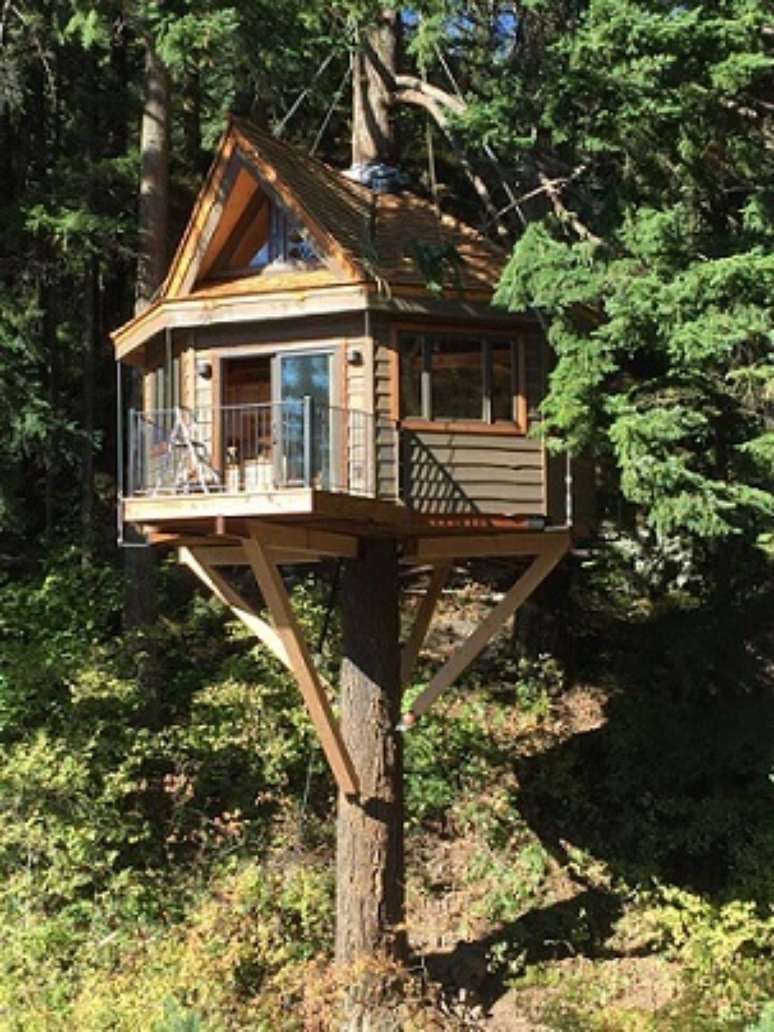 24. Casa na árvore com pilares de madeira na estrutura