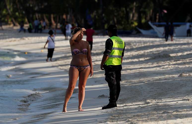 Policial pede que turista deixe praia das Filipinas durante interdi&ccedil;&atilde;o em Boracay 26/04/2018 REUTERS/Erik De Castro