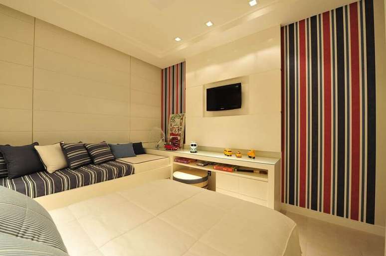 18. O modelo listrado vermelho e azul de papel de parede para quarto masculino deu mais cor ao quarto com decoração clean