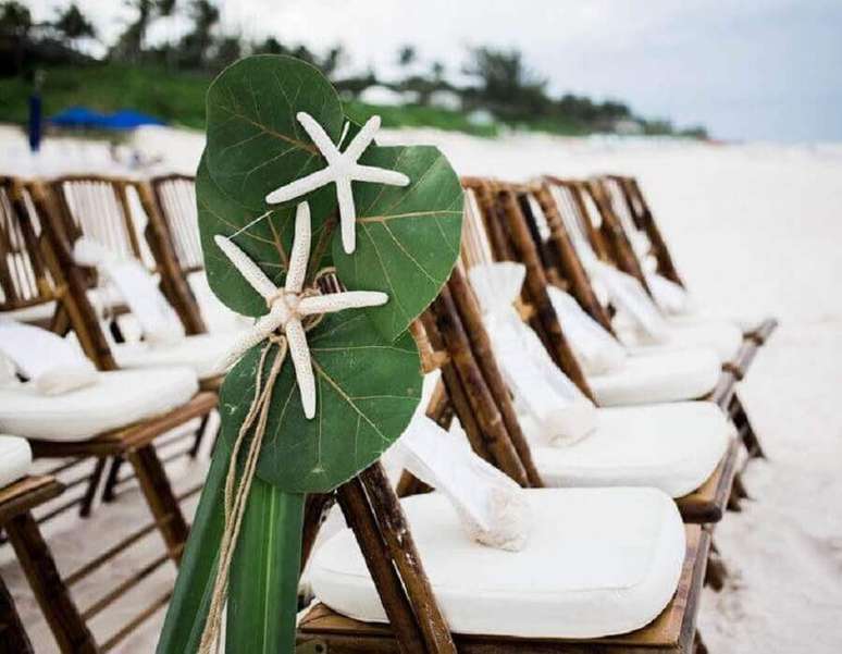 39. Cadeiras decoradas com folhagens e estrelas do mar para casamento na praia