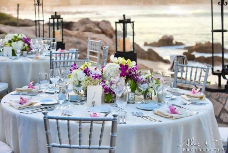 17. Arranjo de flores decorando a mesa de noivado na praia