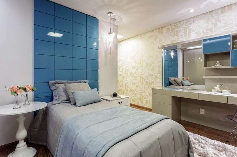 26. Decoração para quarto feminino com cabeceira azul e papel de parede com estampa de sapatos