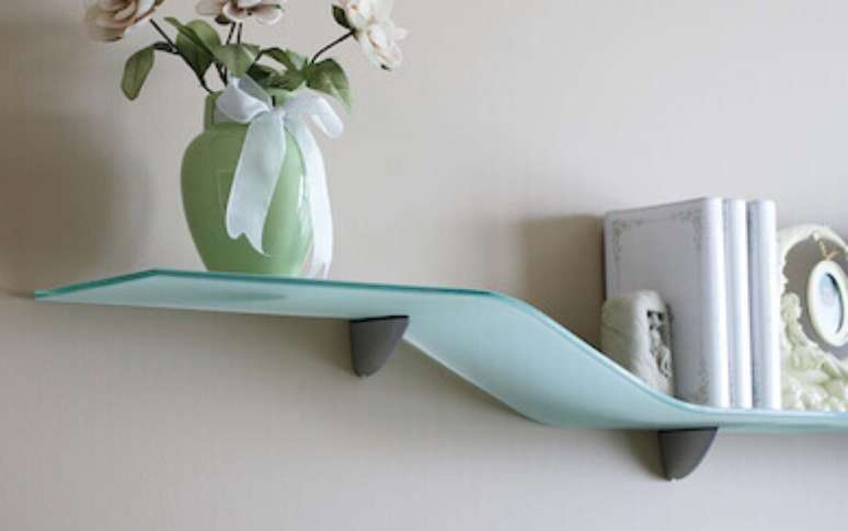 56. Prateleira de vidro com objetos decorativos