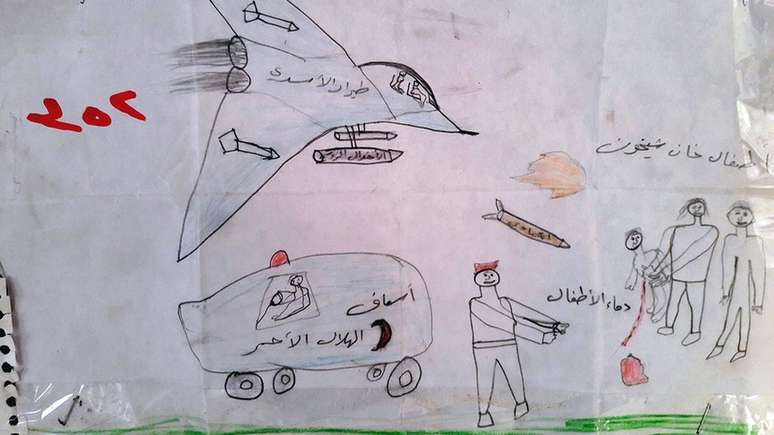 As legendas neste desenho dizem: "Força aérea de Assad (presidente da Síria)", "ambulância", "as crianças de Khan Sheikhoun" e "sangue das crianças". Segundo a ONU, a cidade de Khan Sheikhoun foi palco, em abril de 2017, de um ataque químico promovido por forças do governo e que deixou dezenas de mortos, entre eles, várias crianças; o governo nega ter realizado o ataque.