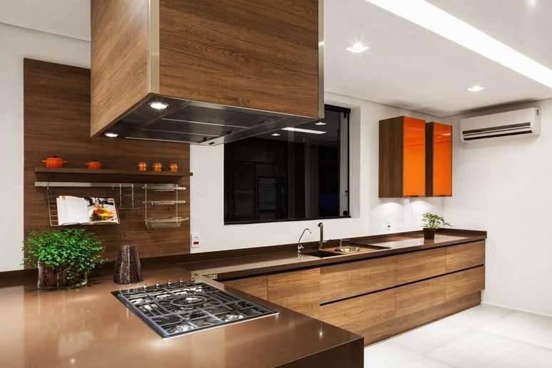 16. A cozinha com pedra silestone marrom e armários de madeira ganhou um clima muito aconchegante