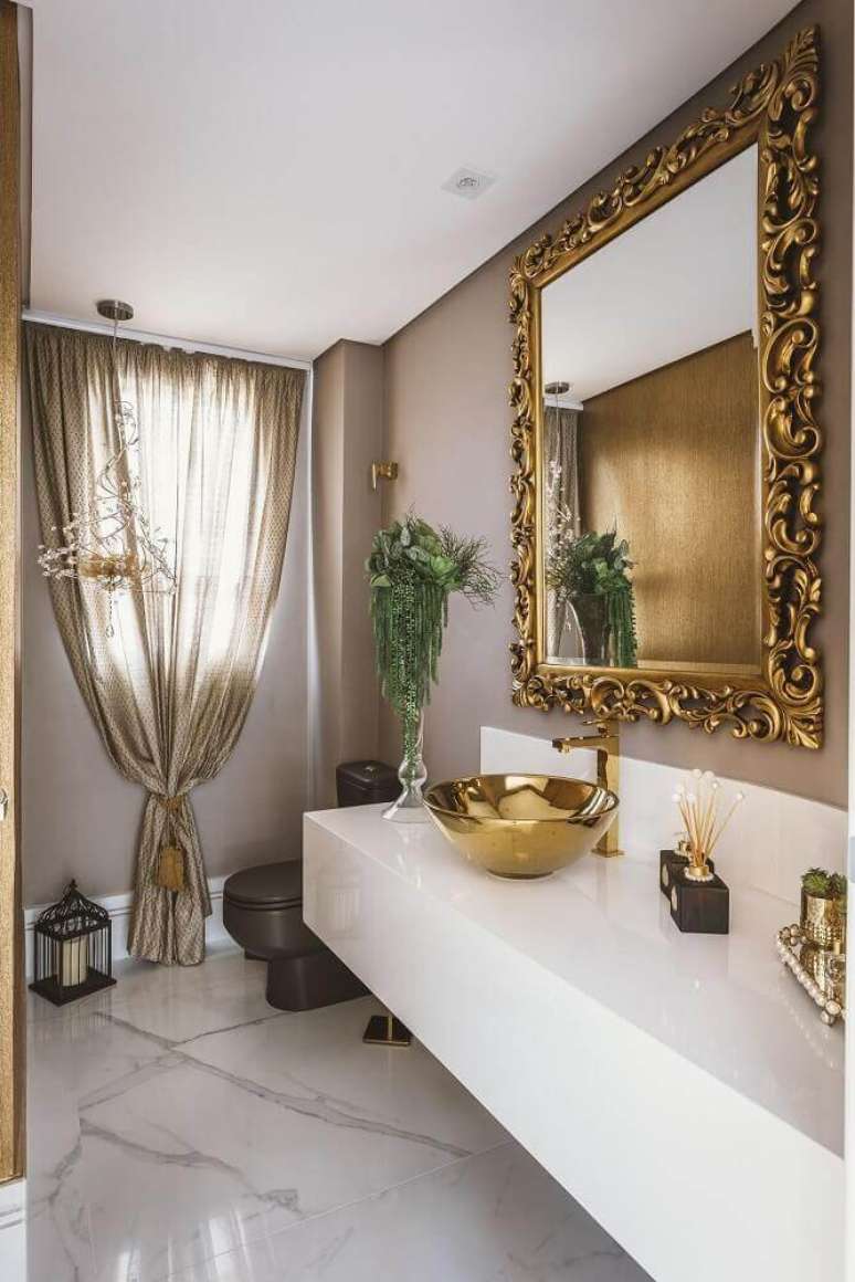 10. Banheiro com decoração sofisicada com bancada de silestone branco e cuba dourada