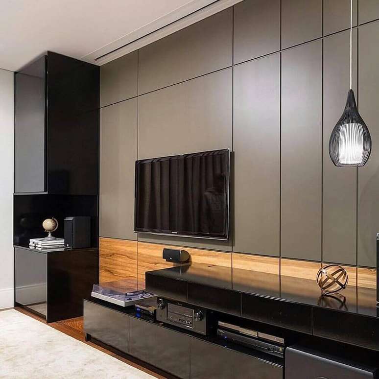 2. Sofisticado painel para sala de estar em tons de cinza e com detalhes de madeira para trazer a sensação de conforto ao ambiente.