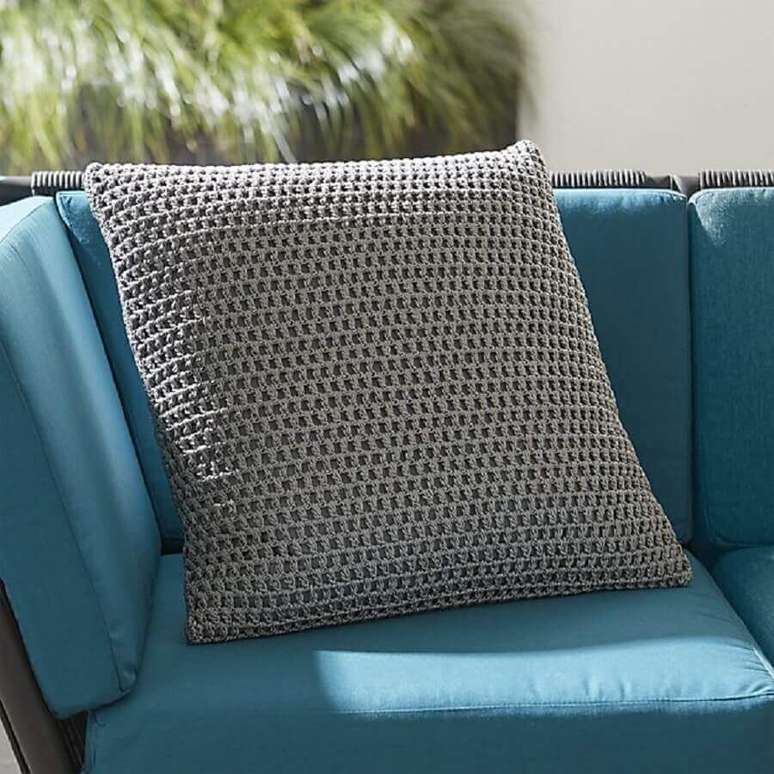 9. Modelo simples de capa de almofada de crochê cinza combinando com o sofá em tom de azul
