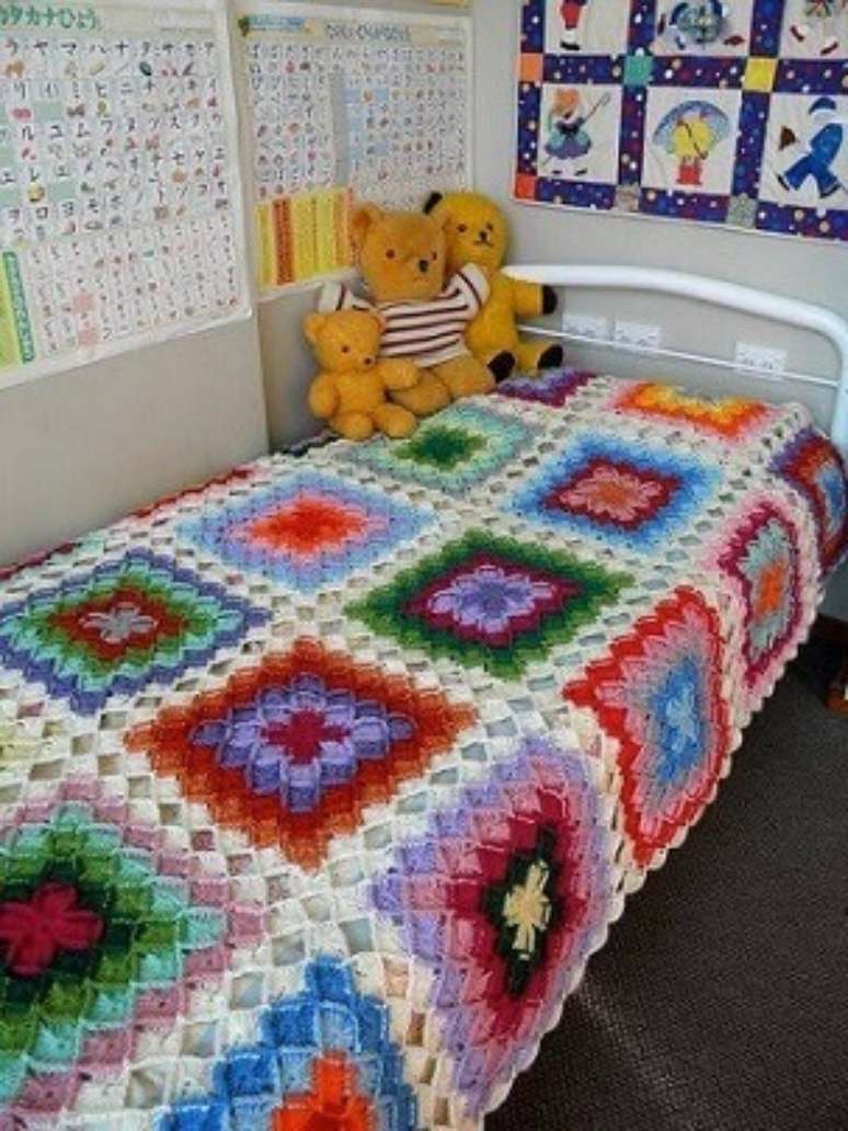 27. Colcha de crochê colorida em quarto infantil