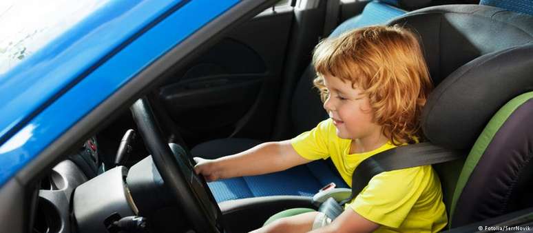 Uma criança fingindo estar ao volante posa para uma foto. No caso flagrado em Recklinghausen, menino estava de fato controlando veículo.  