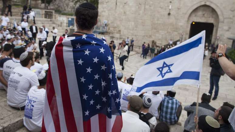 A man wearing an American flag watch the flags march outside Damascus Gate on May 13, 2018 in Jerusalem, Israel.