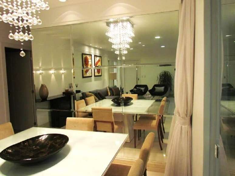 42. Sala de jantar decorada com parede de espelho bisotado