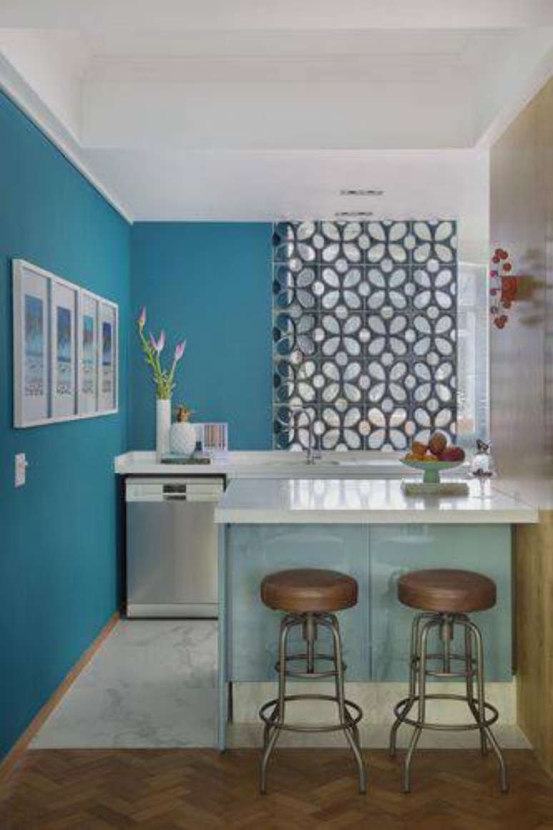 77. As banquetas marrons contrastam com o balcão de cozinha com tons de azul.