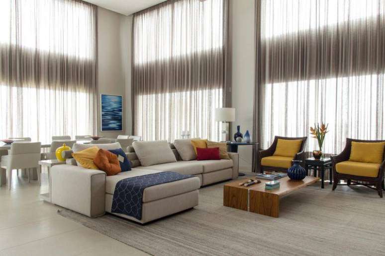 9. Sala de estar bem esposa decorada com sofá confortável e com almofadas coloridas