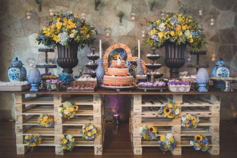 33- Decoração de casamento rústico com vasos, arranjos de flores e pallets