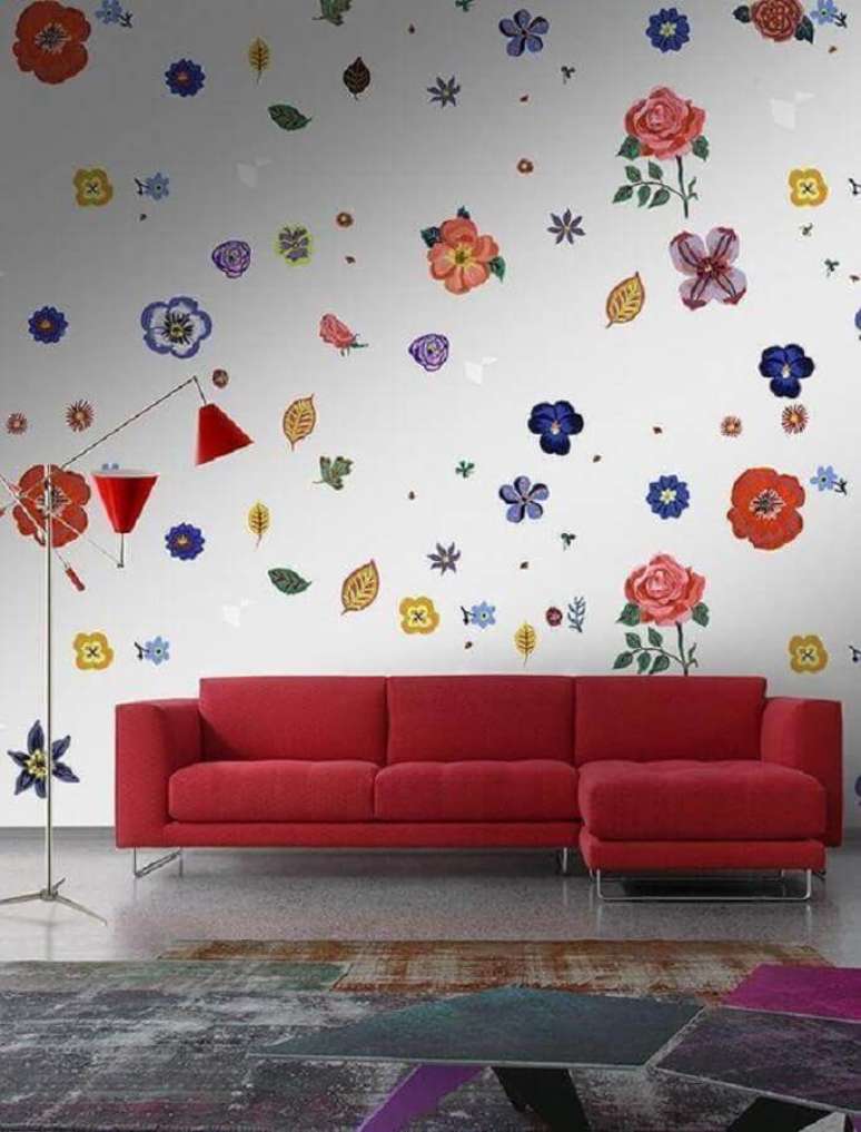 27. O papel de parede todo com estampa floral ficou perfeito com o modelo vermelho de sofá com chaise