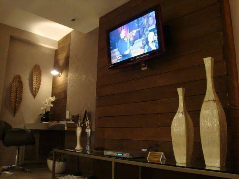 34. Painel de madeira para TV em ambiente &ldquo;quente&rdquo;. Projeto de Ana Cinthia Lopes