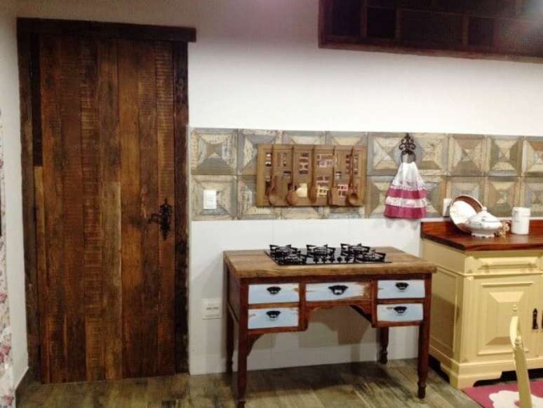 10. Este aparador de madeira de demoli&ccedil;&atilde;o foi reaproveitado como apoio para o cooktop. Projeto de Martha Lilianne Grucci