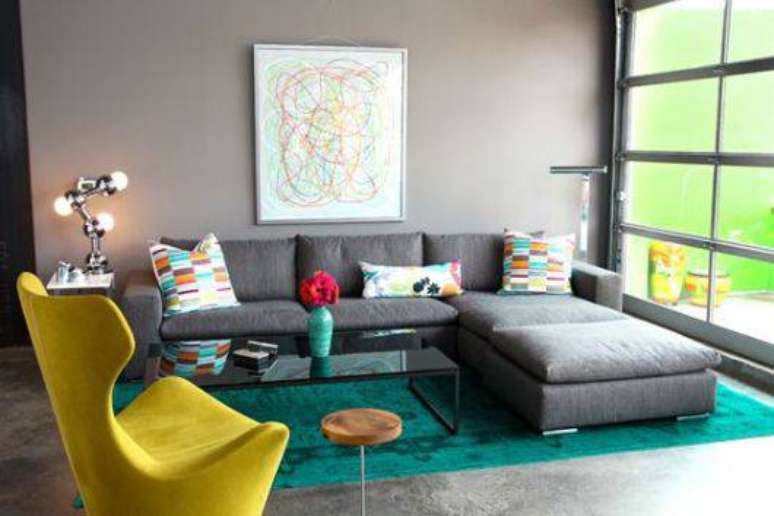 7. O contraste do sofá com chaise cinza e a poltrona amarela ficou perfeito