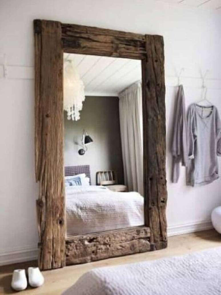 12. Quarto rústico decorado com grande espelho com moldura de madeira de demolição