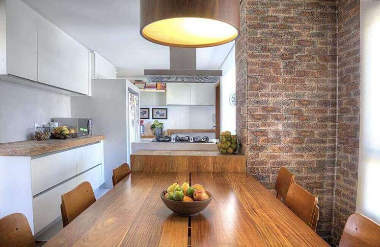 2. O papel de parede de tijolinho é uma maneira de decoração rústica e barata para se implementar em casa, como nessa sala de jantar rústica