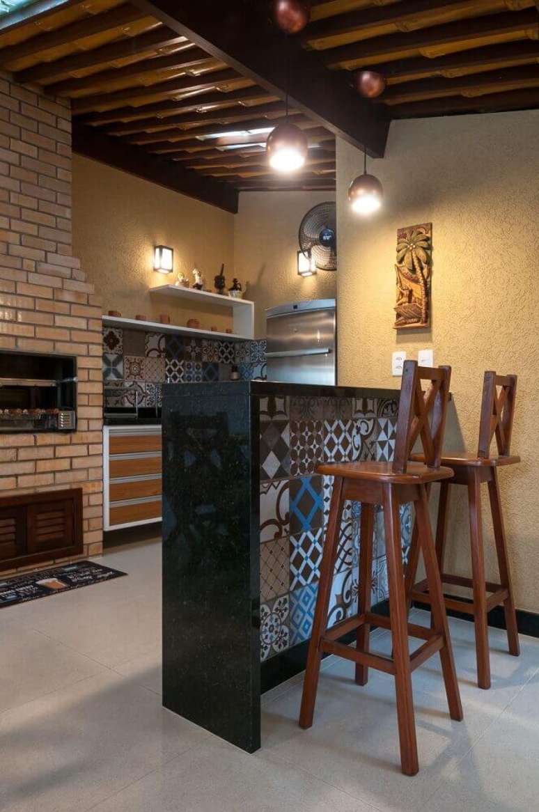 49. Varanda r&uacute;stica com revestimento de azulejo hidr&aacute;ulico e tijolinho