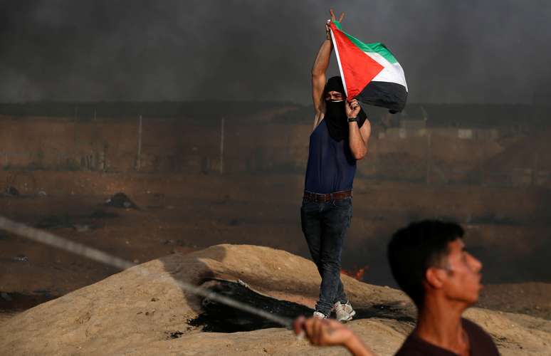 Manifestante segura bandeira palestina em protesto na fronteira Israel-Gaza
 18/5/2018      REUTERS/Mohammed Salem 