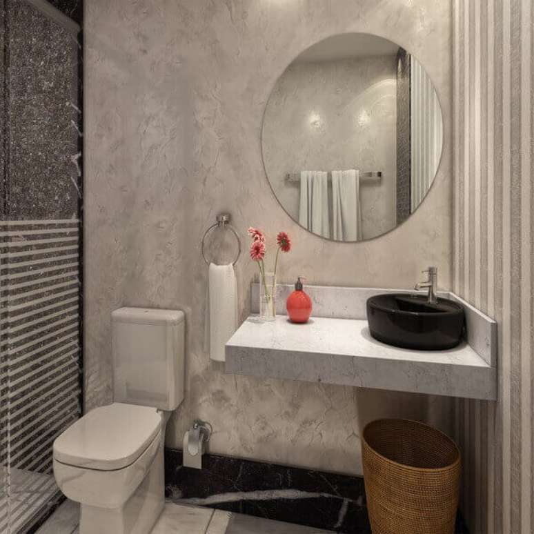 5- A Bancada de banheiro em mármore branco com cuba preta valoriza o ambiente.