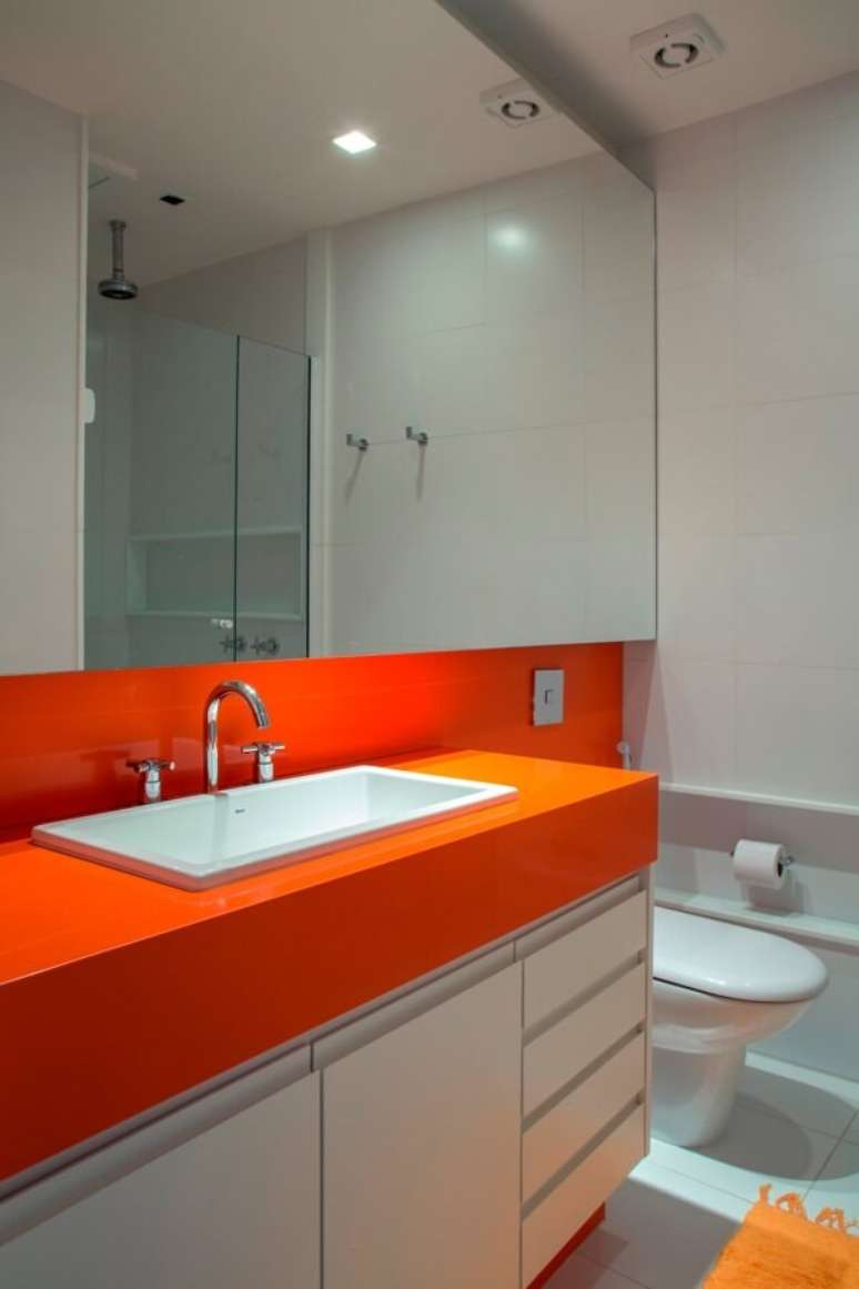 21- Bancada de banheiro em silestone colori o ambiente com um chamativo tom laranja