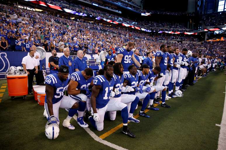 Jogadores do Indianapolis Colts se ajoelham durante a execução do hino nacional norte-americano