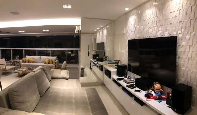 36. Revestimento de parede 3D atr&aacute;s da TV em sala de estar. Projeto de Ana Cinthia Lopes