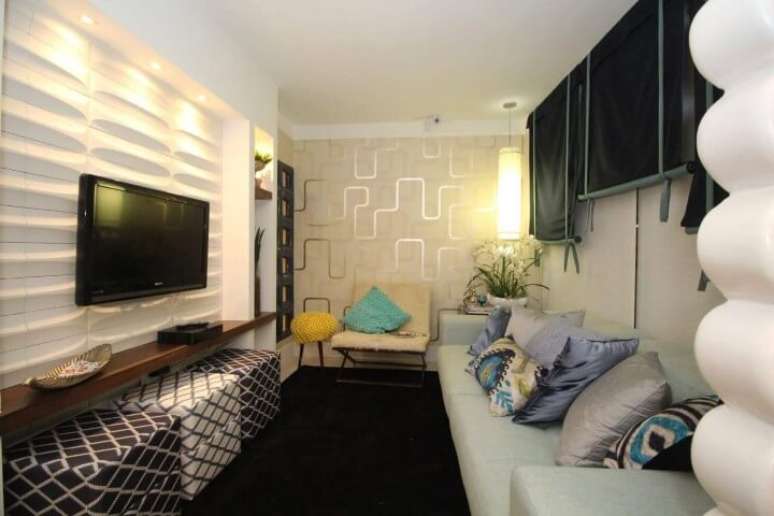 54. Revestimento 3D na parede atr&aacute;s da TV e papel de parede com padr&atilde;o em sala de estar estreita. Projeto de Paragua&ccedil;u S&aacute;
