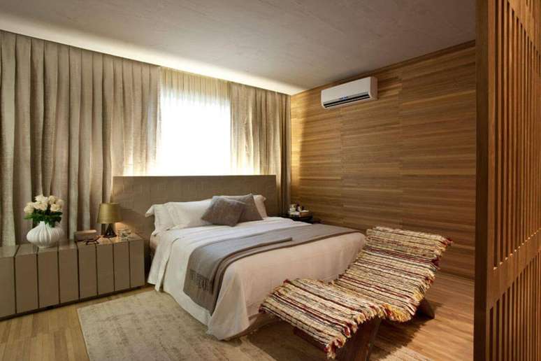6. Neste quarto de casal, o revestimento do ch&atilde;o&nbsp;se estende at&eacute; a parede. Projeto por Denise Barretto