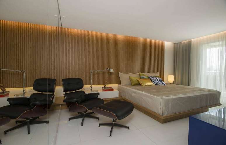 7. O revestimento de madeira refletido pelo espelho deixa o quarto de casal mais amplo. Projeto por Rodrigo Maia