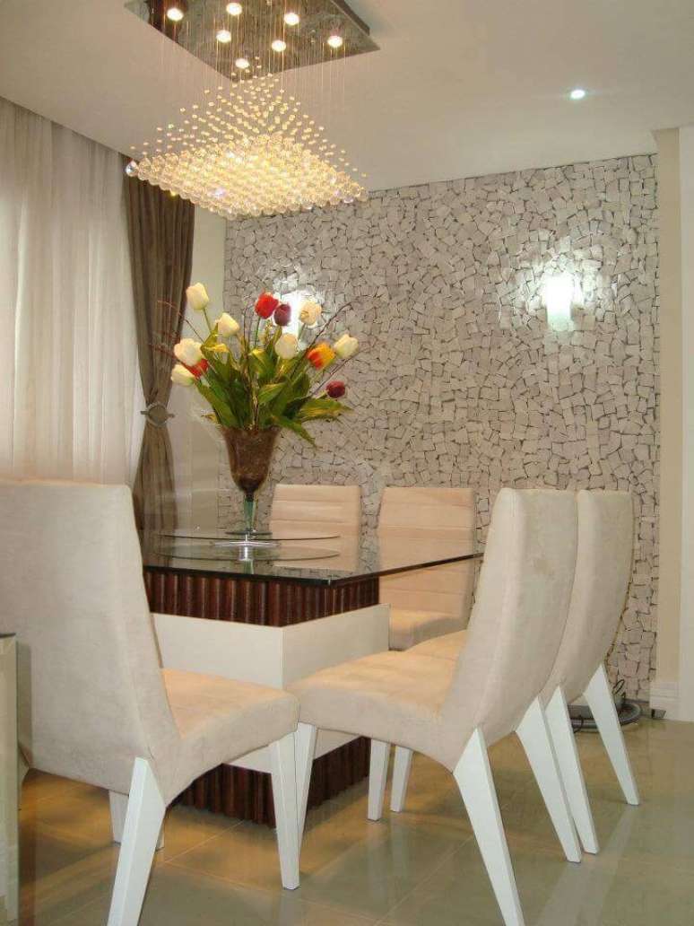 34. As pedras ao fundo da sala de jantar como revestimento de parede criam contraste com o plafon de cristal. Projeto por Fernanda Hoffmann