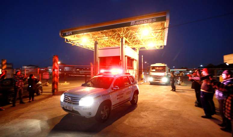 Carro de polícia escolta caminhões-tanque em posto de gasolina de Canoas, no Rio Grande do Sul 25/05/2018 REUTERS/Diego Vara