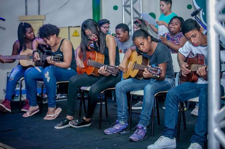 Alunos têm aula violão no projeto Rock das Mangueiras