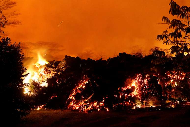 A lava da erupção do vulcão Kilauea atravessa rua no Havaí.