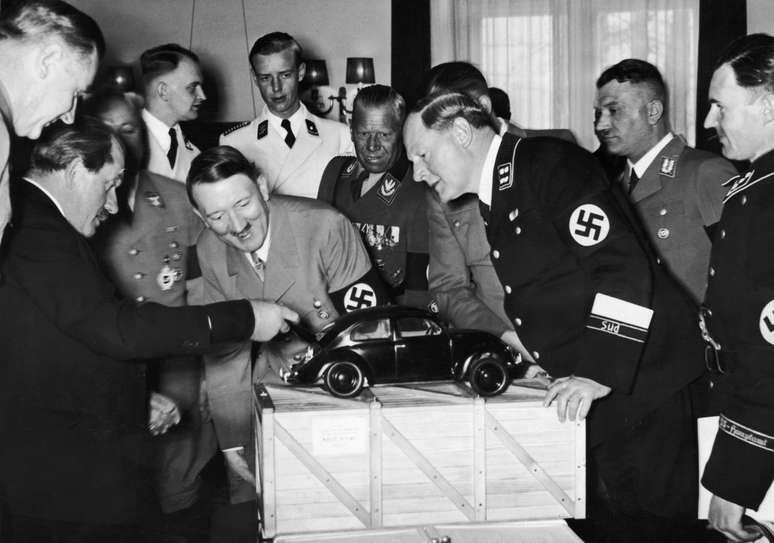 Ferdinand Porsche (esq.) explica a Hitler seu projeto de carro popular "Volkswagen"