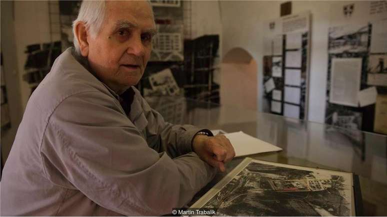 Vintrova Mandrholec posa com fotos de sat&eacute;lite do campo de trabalhos for&ccedil;ados onde ficou preso (Cr&eacute;dito: Martin Trabalik)